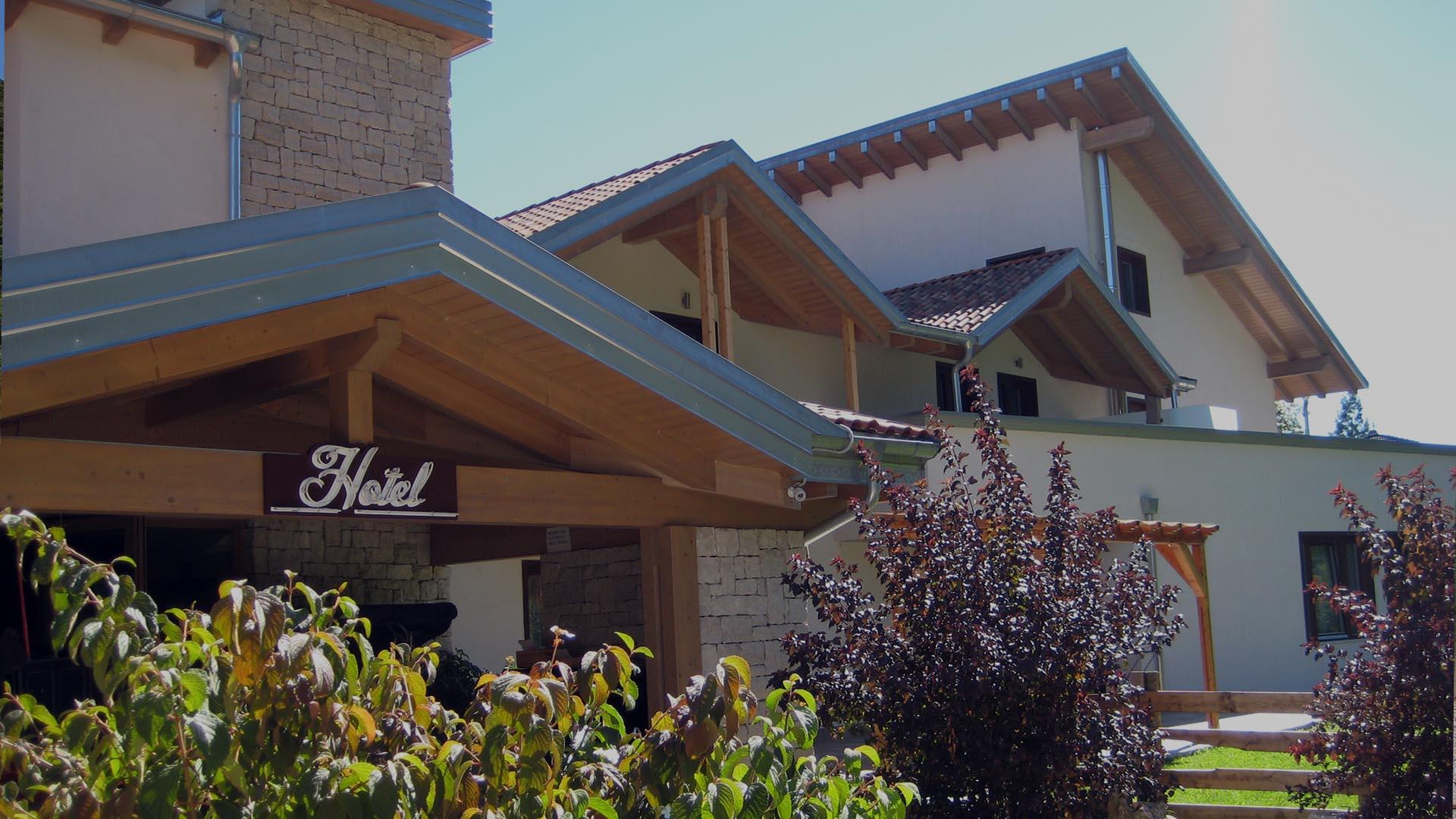 Hotel in stile rustico con tetto in legno e giardino verde.