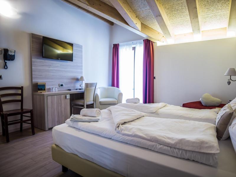 Camera d'hotel accogliente con letto matrimoniale, TV e arredamento moderno.