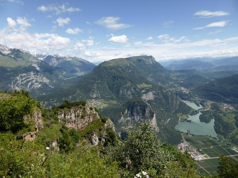 Panorama montano con laghi e valli, cielo sereno e verde rigoglioso.